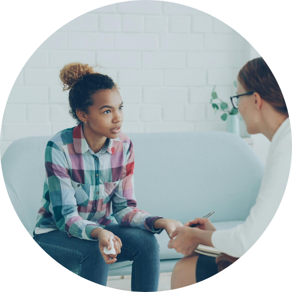 A teen girl speaking with a therapist.