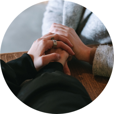 Two people holding hands in comfort.