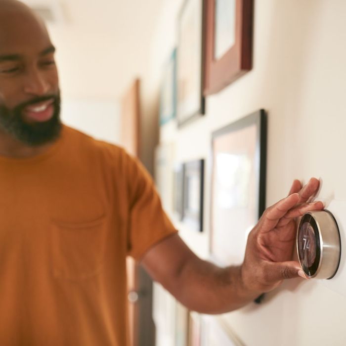 man setting smart thermostat