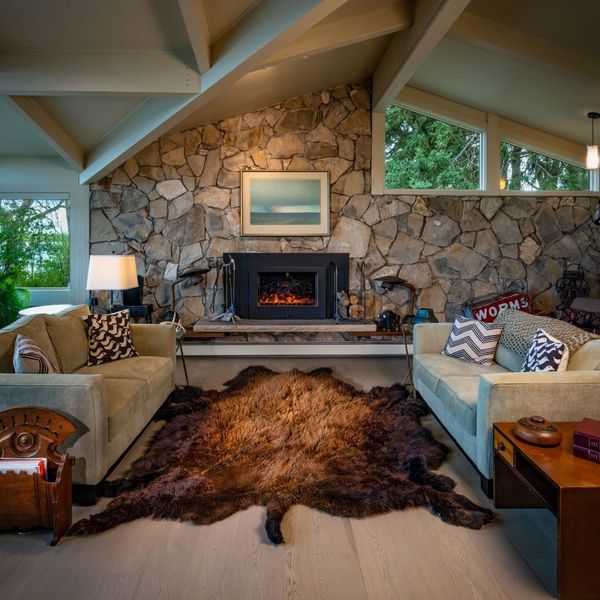Interior design scene featuring a rustic yet modern living room with a large, beautiful bison hide rug.