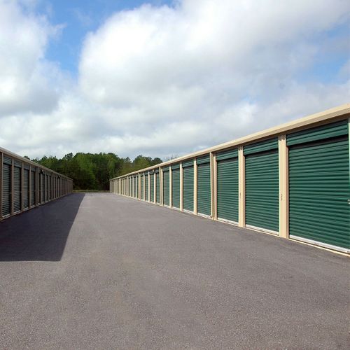 Outdoor storage units with closed green doors.