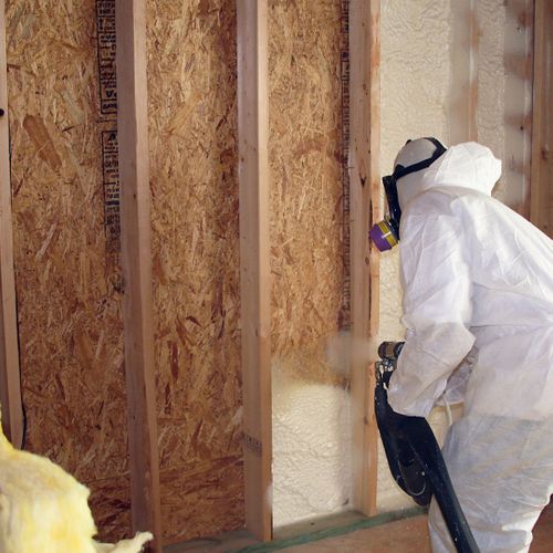 Spraying insulation on a wall