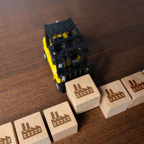 Toy forklift moving wooden blocks with factory symbols