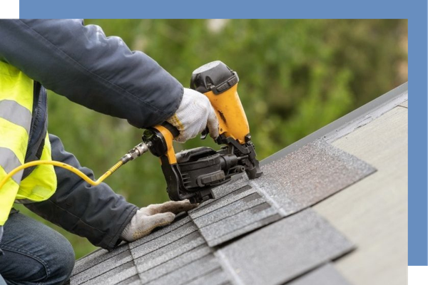 person working on roof shingles