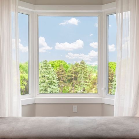 Bay window in a bedroom overlooking trees