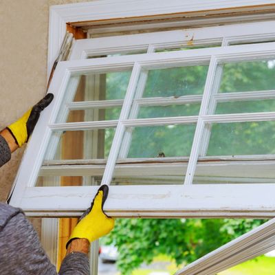 Man replacing old chipped window frames