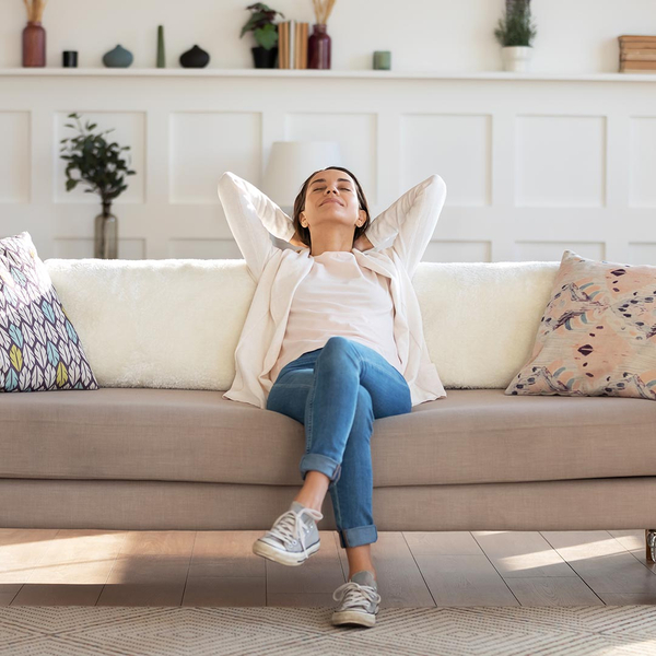 Happy, relaxed woman sitting on a sofa in a clean home