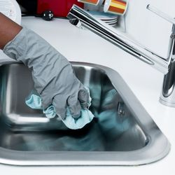 Image of a person cleaning a sink
