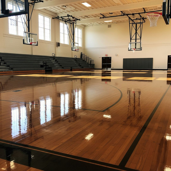A school gymnasium with a freshly cleaned and polished wooden floor. A school gymnasium with a freshly cleaned and polished wooden floor.