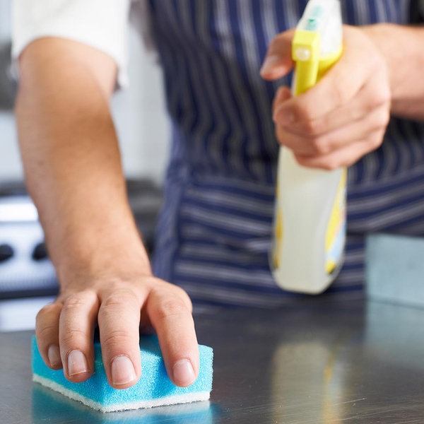 Man cleaning restaurant kitchen counter