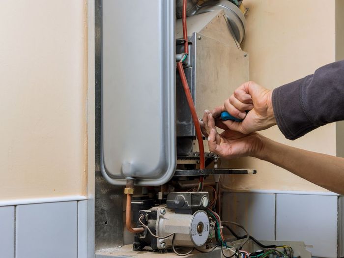 closeup of a contractor working on a tankless water heater