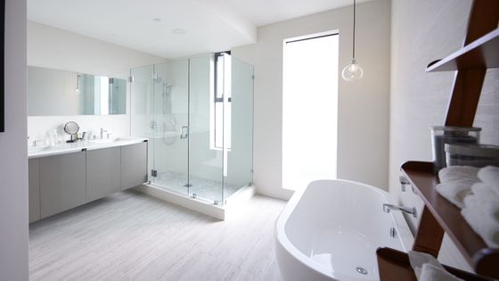 Bright, minimalist bathroom featuring a spacious walk-in shower, a freestanding tub, and a double vanity.