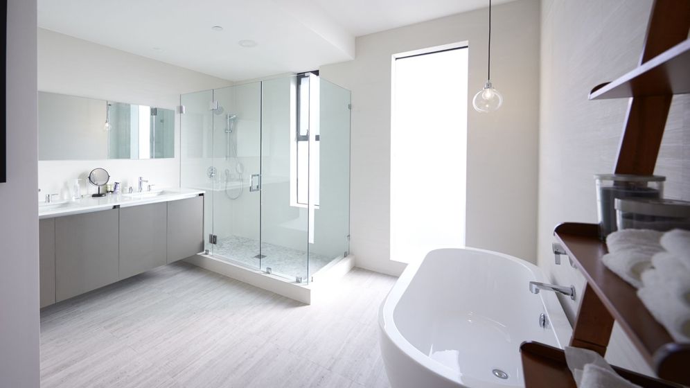 Bright, minimalist bathroom featuring a spacious walk-in shower, a freestanding tub, and a double vanity.