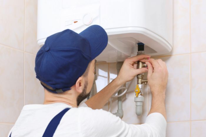 a man fixing a tankless water heater