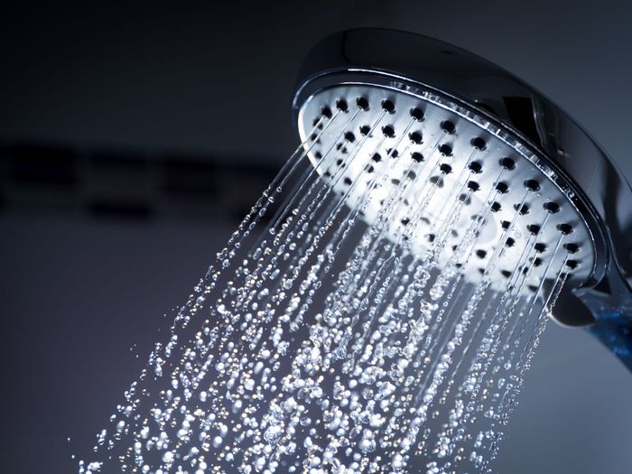 closeup of a showerhead with water running