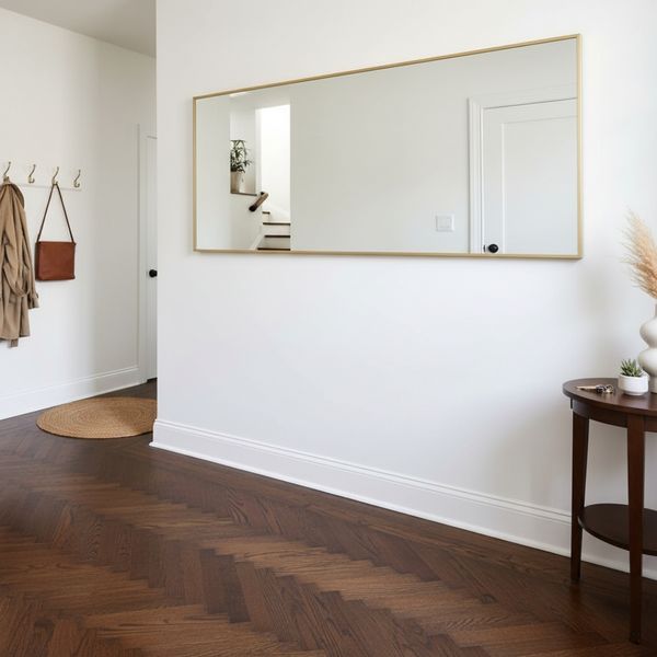A small entryway with dark herringbone wood flooring
