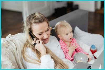 woman sitting on couch by daughter talks on phone woman sitting on couch by daughter talks on phone