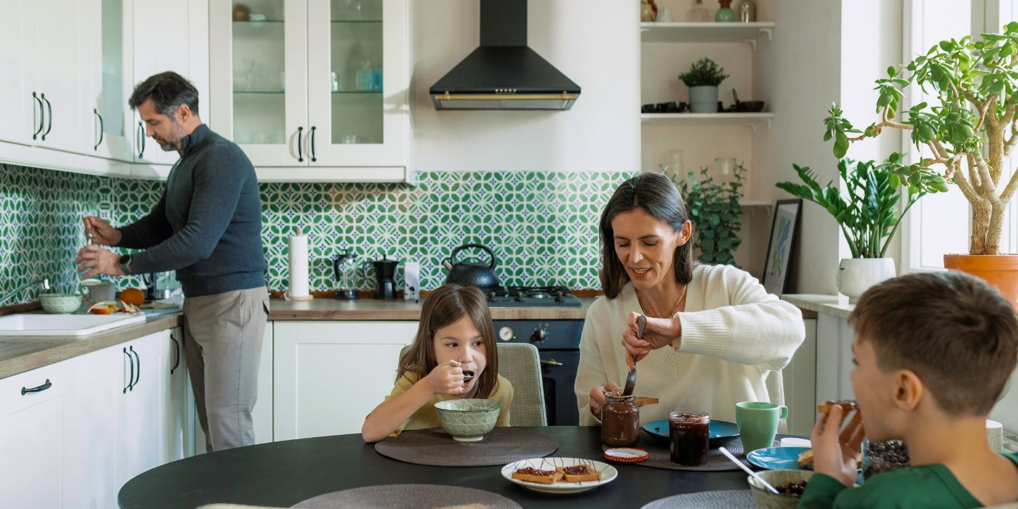 family in renovated kitchen with white cabinets and colorful backsplash family in renovated kitchen with white cabinets and colorful backsplash