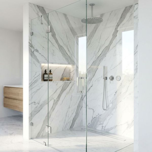 Modern walk-in shower with frameless glass enclosure, marble tile, and rainfall showerhead.