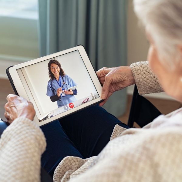 an elderly person on a tablet talking to a doctor