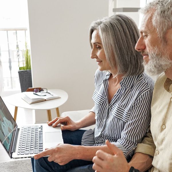two elderly people on a laptop with a doctor