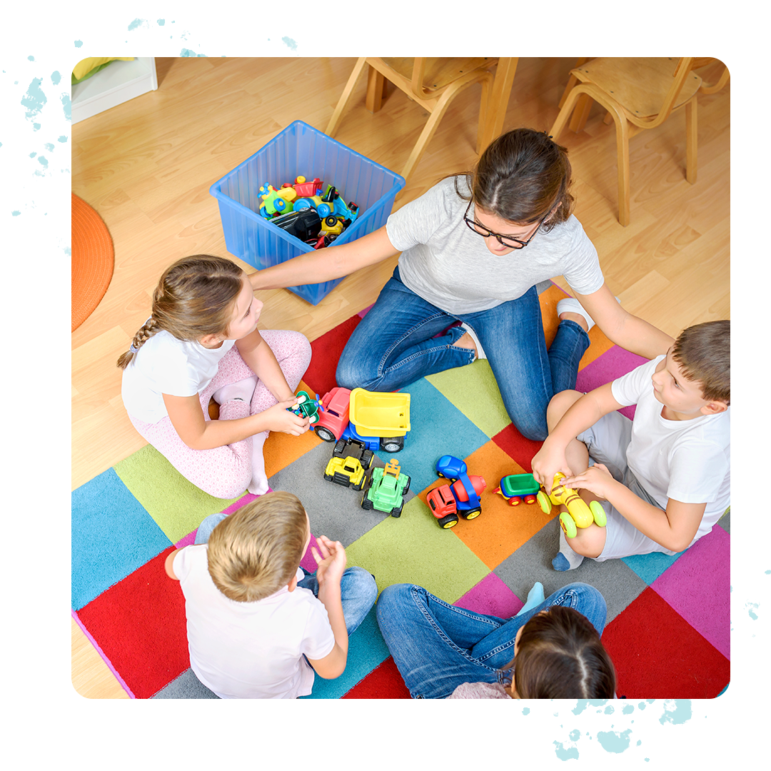 Teacher in a circle with students and their toys