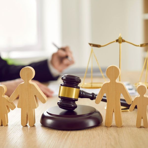 Wood cutouts of a family with a weight and gavel behind them