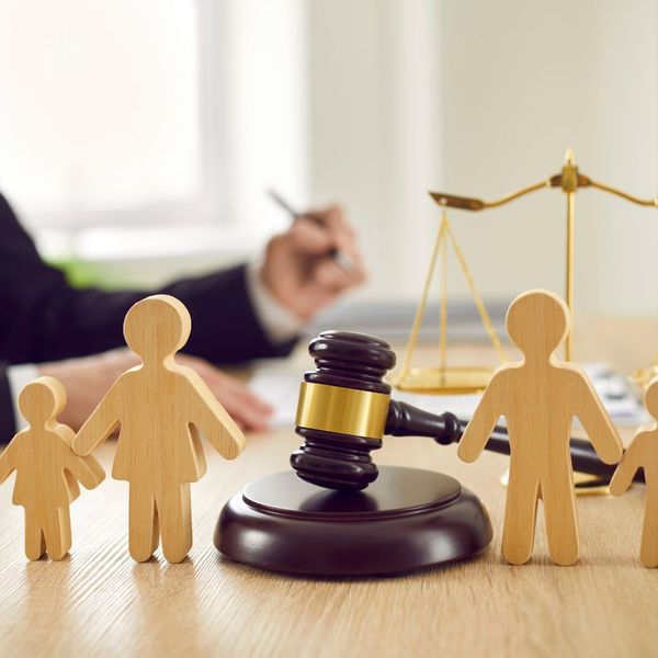 A wooden outline of a family with a gavel in the background