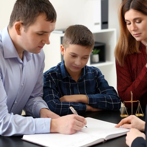 A family of three signing legal paperwork