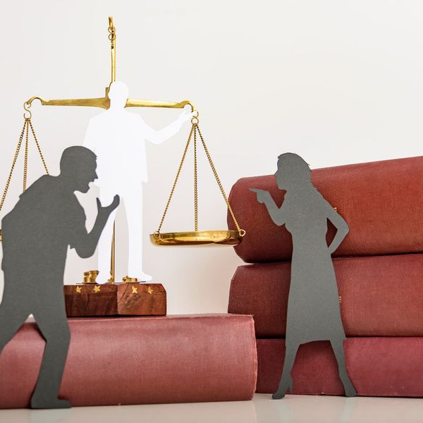 Two black outlines of people arguing with a legal weight in the background and books