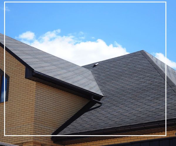 A well maintained roof on a house with a blue sky in the background