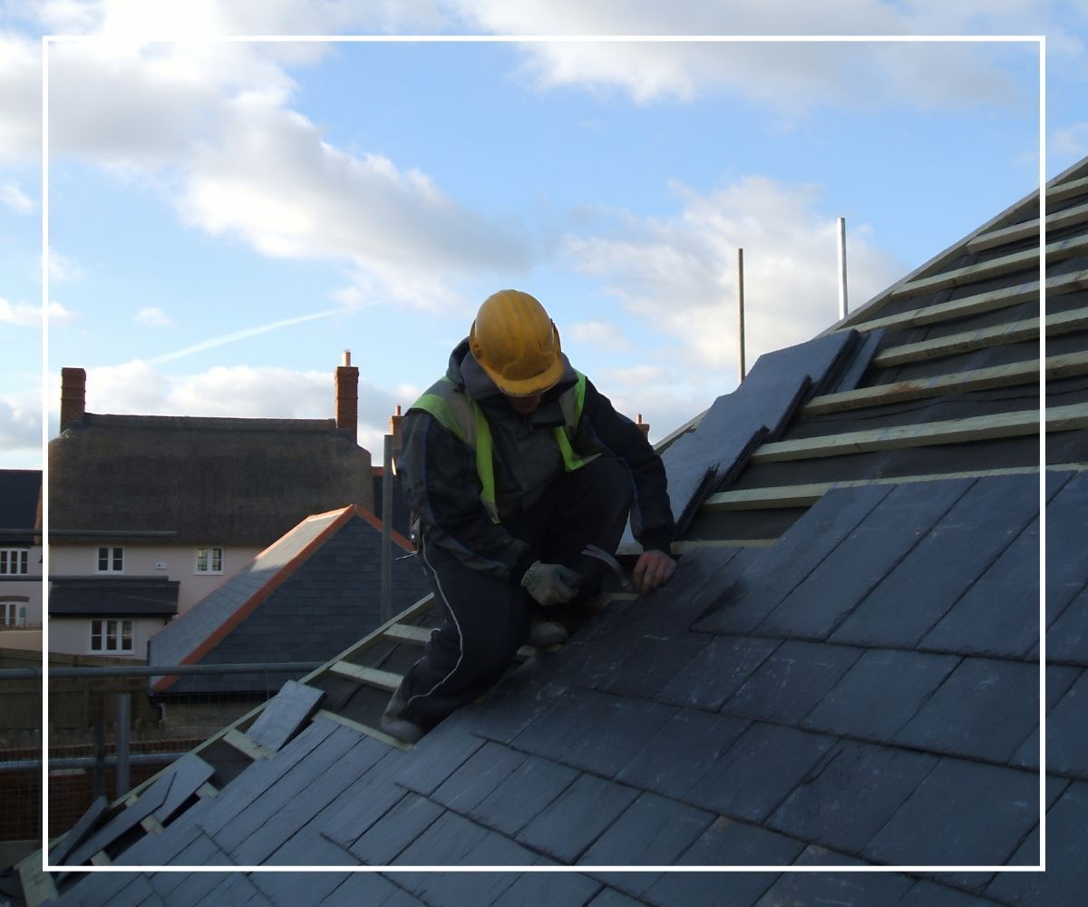 A roofer installing tiles on a roof