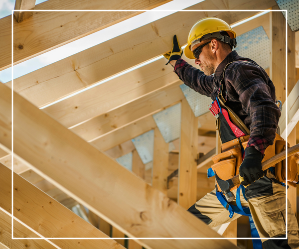 A roofing contractor standing among the framing of a new roofing installation