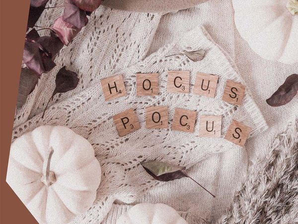 Fall decor with white pumpkins and tiles that say “Hocus Pocus.”