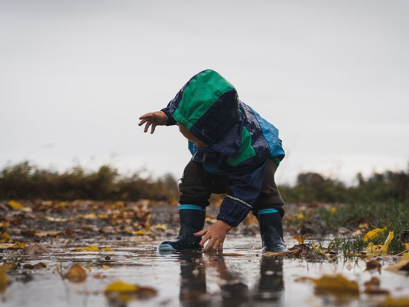 little boy playing in rainy weather 