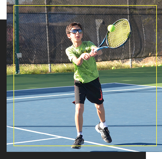 Child returning a tennis ball serve