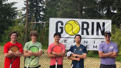 Young men holding their tennis rackets with their coach