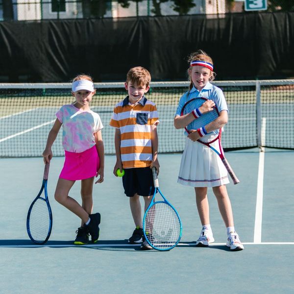 three kids  practicing tennis