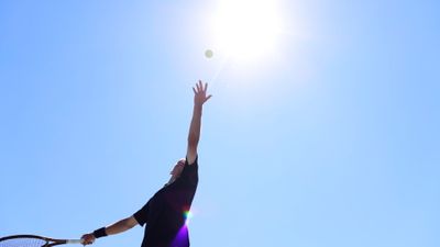 throwing tennis ball to serve 