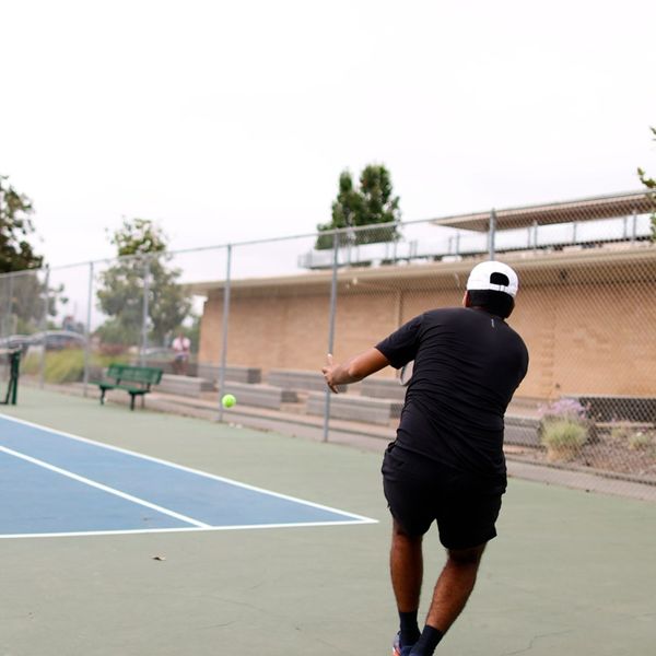 adult playing tennis