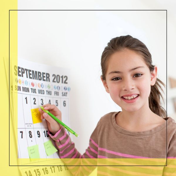 girl smiling while filling out a schedule