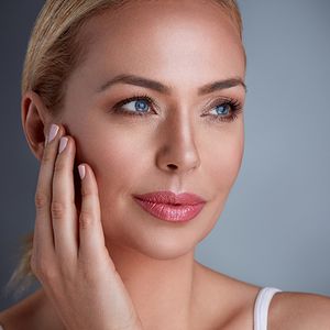 woman feeling her cheek