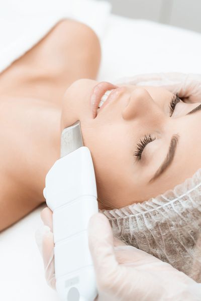 An image of a woman undergoing a laser facial treatment in a spa