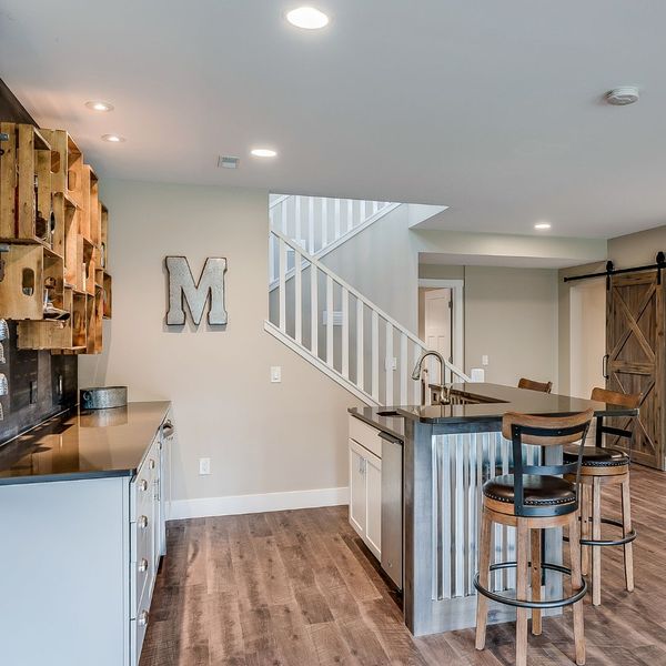 a newly renovated basement with a wet bar