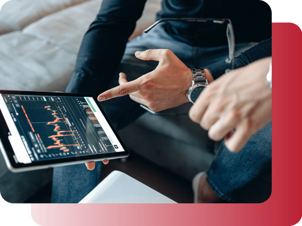 Close-up of a person's hands holding a tablet displaying stock market charts and analysis.