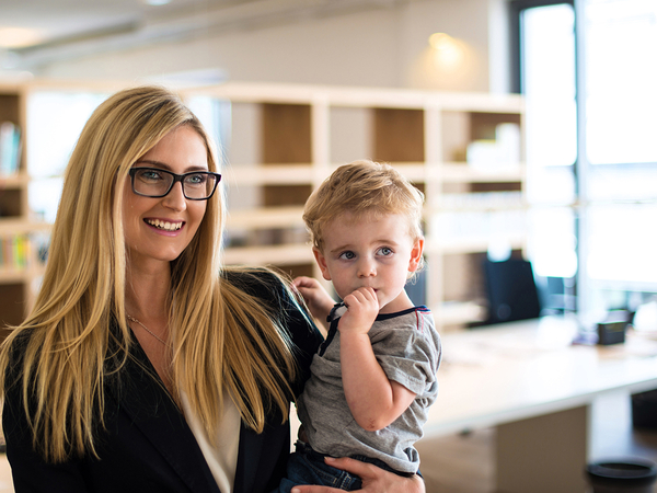 Woman holding a young child on her hip, smiling. 