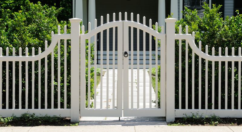 front of house with white fence and gate