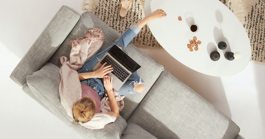 Topview of woman sitting on sofa with her laptop Topview of woman sitting on sofa with her laptop
