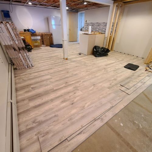 Interior room under construction with exposed framing and plywood subflooring