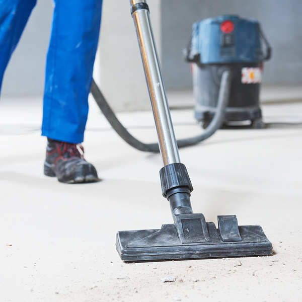 Worker using a vacuum on dust